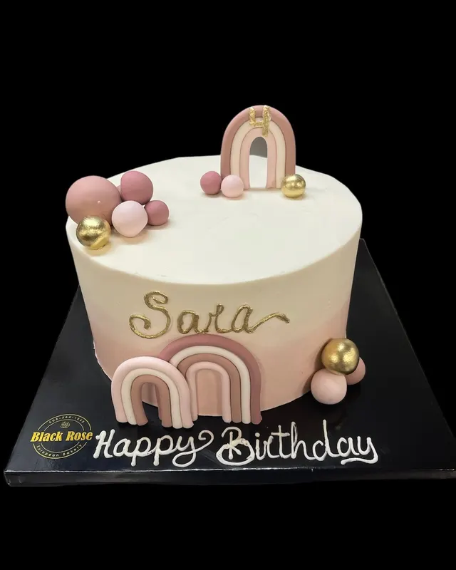Pink and cream birthday cake with arch decorations