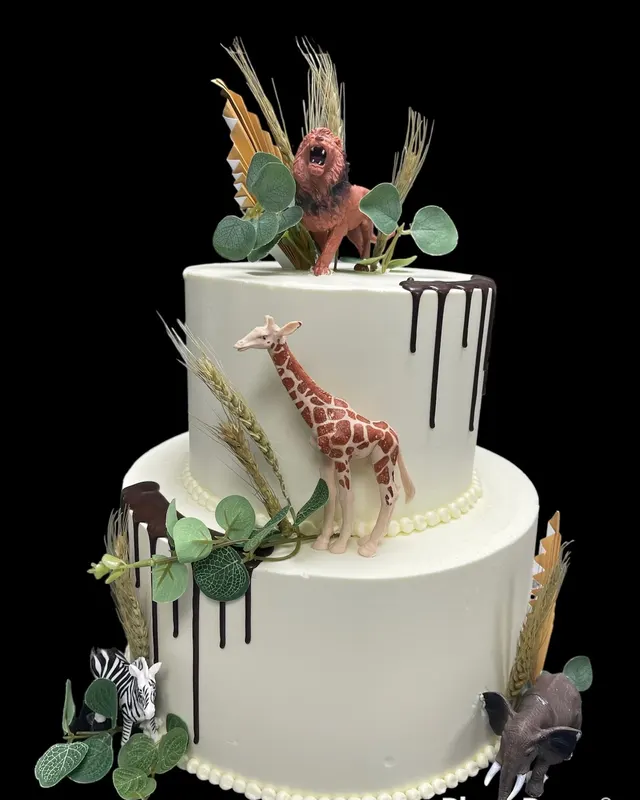 Two-tier white cake with giraffe topper
